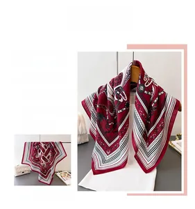 Detail of vintage chain and polka dot patterns on a burgundy silky square scarf