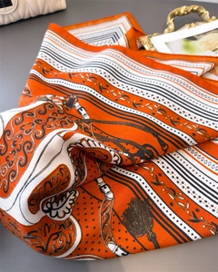 Detailed macro view of silk-texture scarf with equestrian horse and chain patterns