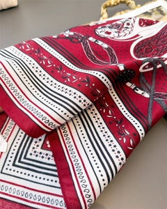 Detailed macro view of equestrian chain pattern on silk scarf with elegant rolled edges