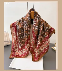 Detail of bohemian leaf pattern scarf on a white ribbed top with chic chain handbag