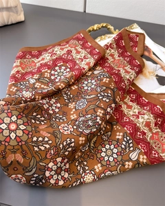 Detailed close-up of retro floral pattern and silk texture on red-brown square scarf