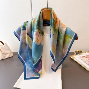 Elegante pañuelo de seda azul y verde con estampado de nenúfares en percha de madera