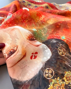 Macro detail of red floral silk scarf featuring traditional art prints and jacquard texture