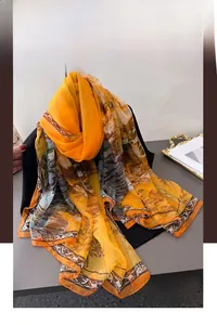 Detailed close-up of vibrant orange floral silk scarf with vintage border pattern