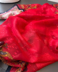 Close-up of red floral jacquard scarf fabric with traditional phoenix and flower patterns