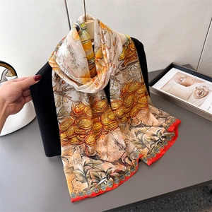 Elegant Chinese style floral print silk scarf with red border displayed on black outfit