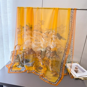 Detailed translucent fabric view of yellow floral silk scarf with elegant drape