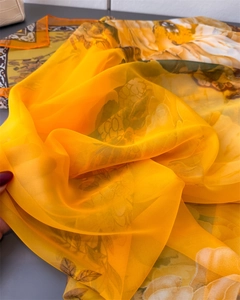 Detail of vibrant orange floral print scarf featuring lightweight semi-transparent fabric