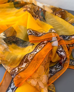 Detail of yellow floral silk scarf with retro bird print and fine orange hem stitch