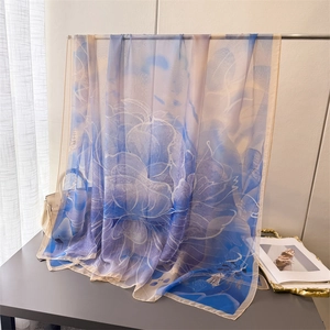 Macro detail of the gradient floral silk scarf with elegant blue and lilac flower patterns