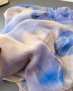 Detailed close-up of gradient blue and purple chiffon scarf with abstract patterns