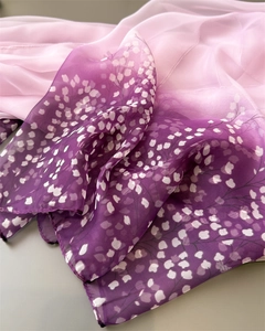 Close-up of lightweight gradient chiffon scarf with white floral print from pink to purple
