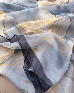 Detail showing the sheer floral fabric texture and neat stitched edges of the scarf