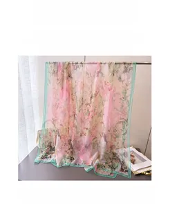 Detailed view of the lightweight floral print shawl in pink and mint green chiffon