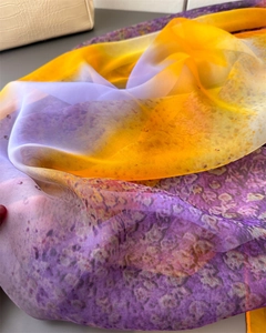 Close-up of semi-transparent silk scarf with yellow-purple gradient and leopard print