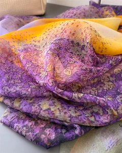 Close-up of semi-transparent silk shawl with purple and yellow gradient leopard print