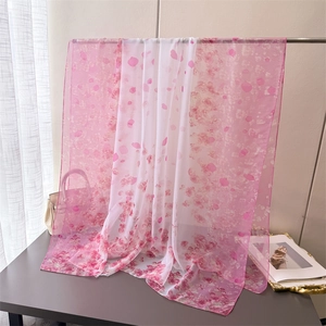 Detailed texture of lightweight pink and white floral print silk scarf draped over a stand