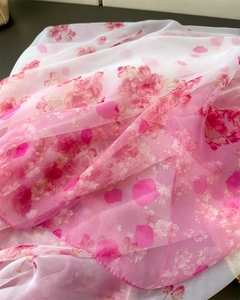 Detailed close-up of translucent chiffon scarf featuring delicate pink floral petal prints