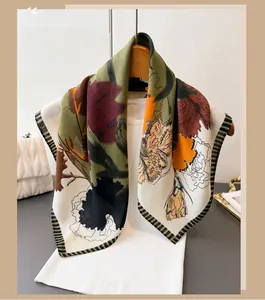 Detail showing elegant floral print scarf paired with a white sweater and leather bag