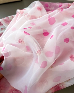Detail showing sheer floral chiffon fabric with soft pink flower petals print on long scarf
