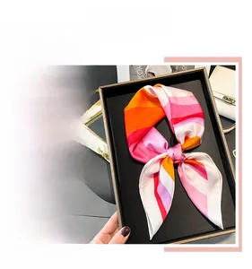 Detail of pink and orange gradient striped satin scarf with silky texture and soft luster