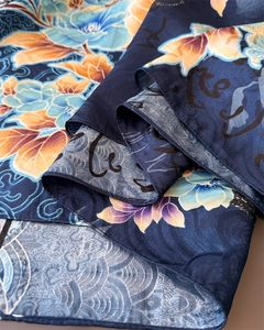 Detail of silk scarf showing peony floral print and traditional cloud patterns in navy blue