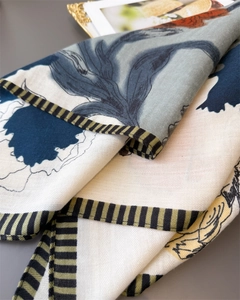 Close-up of floral print cotton-linen scarf showing herringbone texture and striped edges