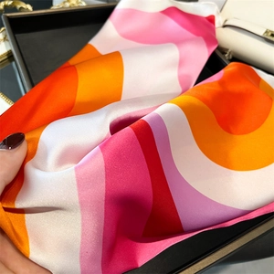 Detailed macro view showing the silky texture and retro wavy pattern of the satin scarf