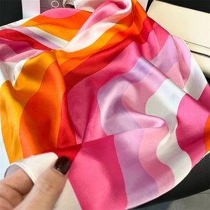 Detail shot of heart print faux silk scarf with colorful wave patterns and satin finish