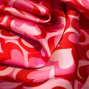 Detailed view of the silky heart-print scarf fabric showing soft draping and texture