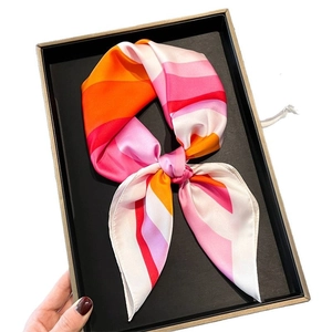 Pink and orange wavy patterned silk scarf presented in a premium black gift box