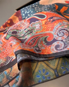 Close-up of multicolored paisley silk scarf showing fine twill texture and bold patterns