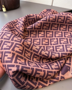 Macro shot of double-sided herringbone silk scarf featuring classic jacquard F-letter pattern