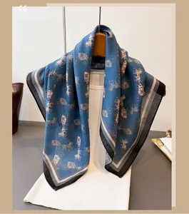 Detail of blue silk scarf featuring vintage horse carriage pattern and striped hem
