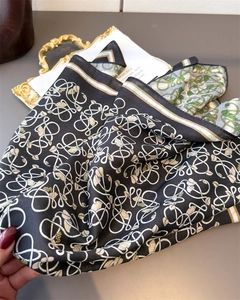 Detail of high-quality herringbone silk scarf with floral patterns on vintage tray