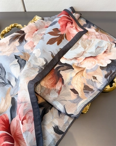 Close-up of herringbone twill texture on silk scarf with floral patterns in metal tray