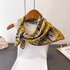 Double-sided herringbone silk scarf in yellow and dark brown displayed on a hanger