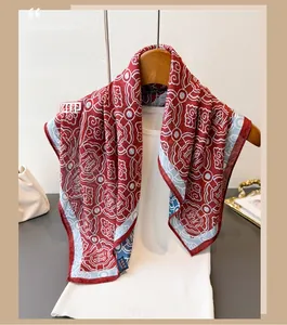 Detail of red silk scarf with traditional pattern and tassels hanging on a hanger