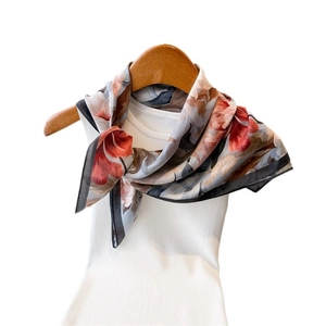 Elegant herringbone patterned silk-like square scarf in brick red and blue on a hanger