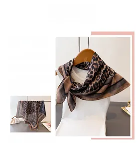 Detail of double-sided silk scarf with herringbone leopard print on stylish apparel