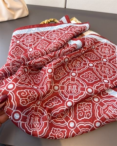 Detail of red silk scarf showing traditional Chinese Fu character and auspicious clouds