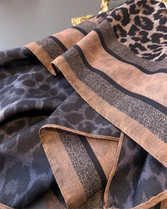 Close-up of dual-tone herringbone leopard print silk scarf showing twill texture and hem
