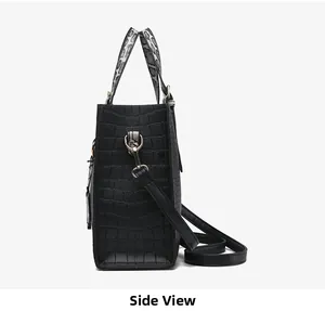 Side view of black crocodile pattern handbag with gold hardware and snake print handle