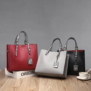 Three crocodile pattern bucket bags in red, grey, and black with faux snake skin handles
