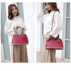 Détails du sac coquille rouge gaufré crocodile avec finitions serpent et boucle dorée