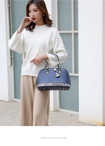 Détails du sac à main bleu avec motif crocodile, serrure en métal et doubles anses