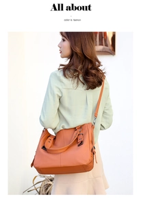 Detail of orange pebble leather tote bag with sturdy handles and adjustable shoulder strap