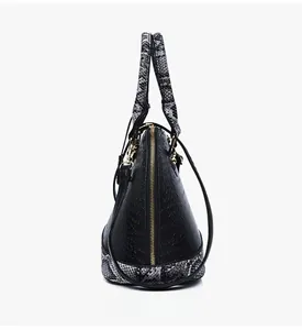 Détail d'un sac à main texturé crocodile avec motifs serpent et fermeture éclair dorée