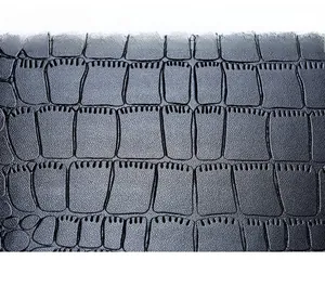Gros plan sur la texture du cuir noir à motif crocodile avec coutures de précision