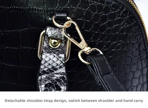 Détail du sac à main crocodile noir avec bandoulière serpent et boucles dorées chic